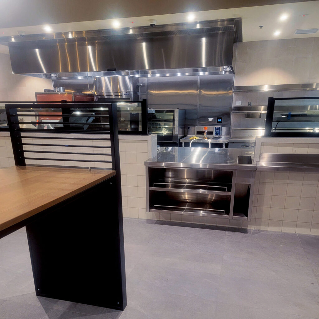 A restaurant kitchen in Santa Clarita after a deep clean by Cyclone Janitorial, with stainless steel surfaces shining and spotless equipment.